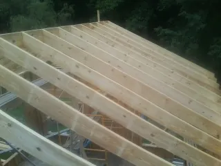 New roof rafters set over an addition before sheathing in Auburn